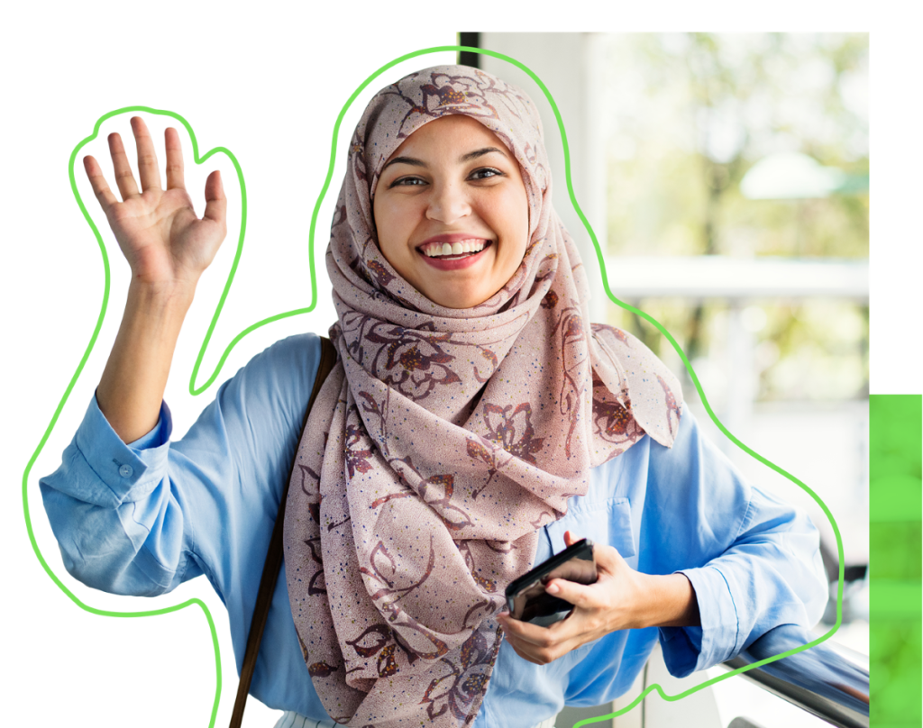 A person wearing a headscarf smiling and waving at the camera