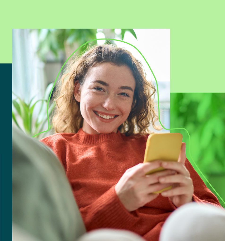 A person on her phone smiling at the camera