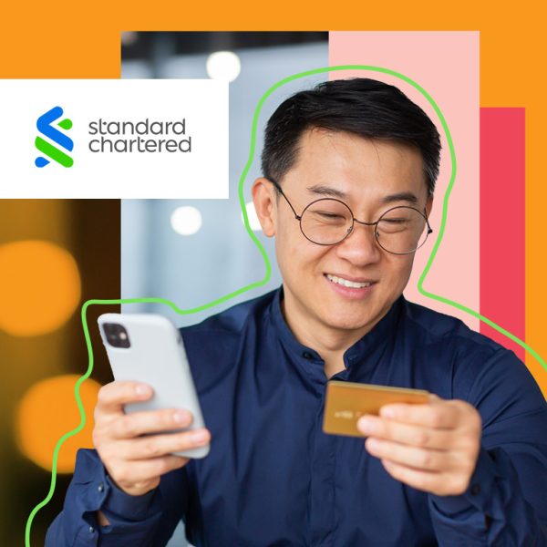 Man smiling holding phone and payment card