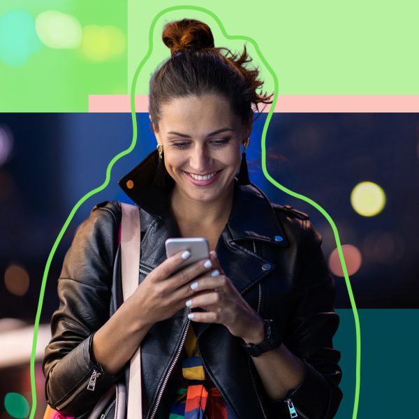 Young woman looking down on smartphone while smiling