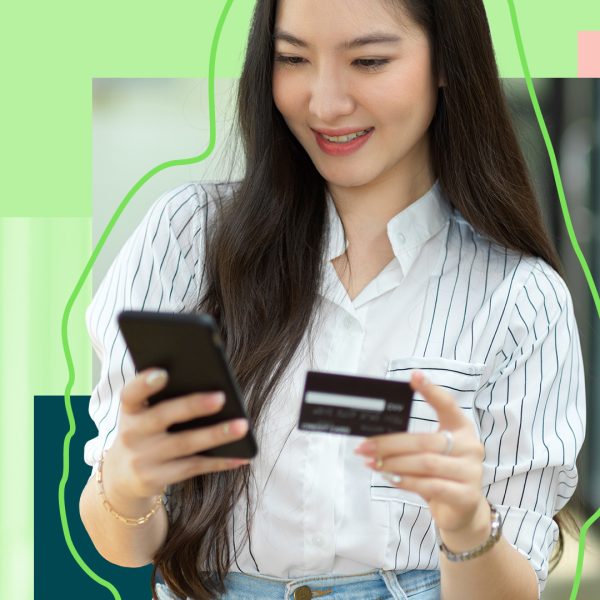 Young woman holding her smartphone and bank card