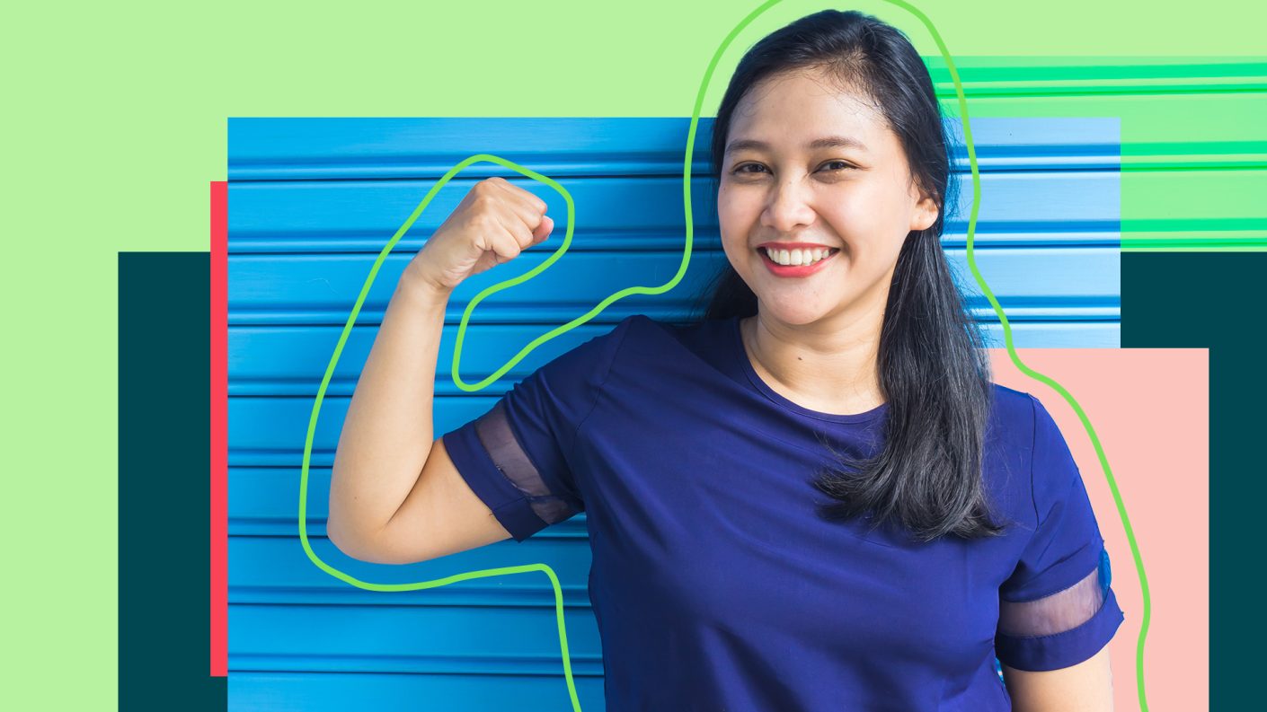 Woman in blue T-shirt flexes arm