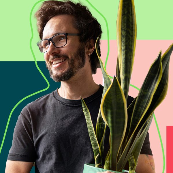 Man with glasses holding plant