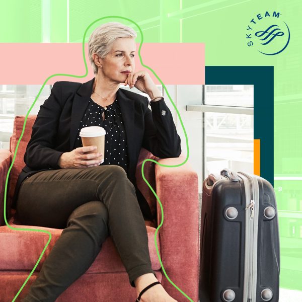 Lady with a cup of coffee and suitcase waiting in airport