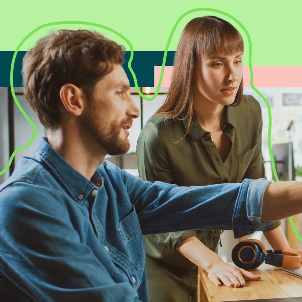 Two people collaborating, male pointing at computer screen