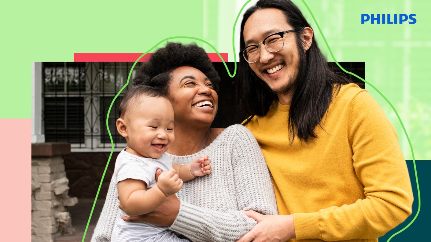 Happy family of two parents and a baby, smiling