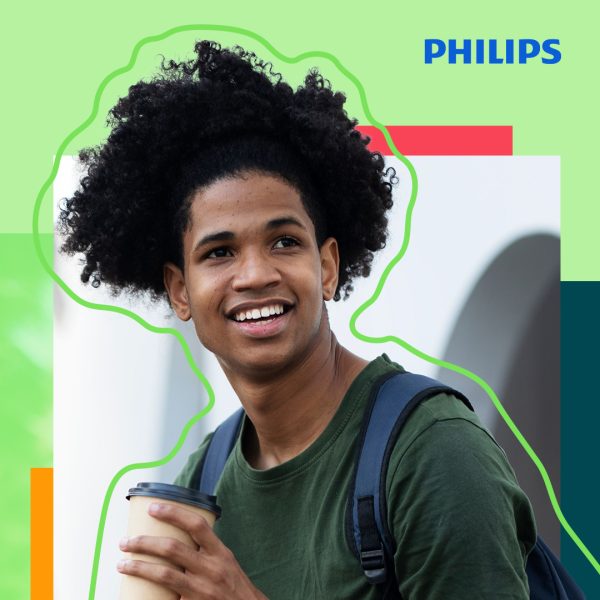 Young guy with curly hair holding a cup of coffee