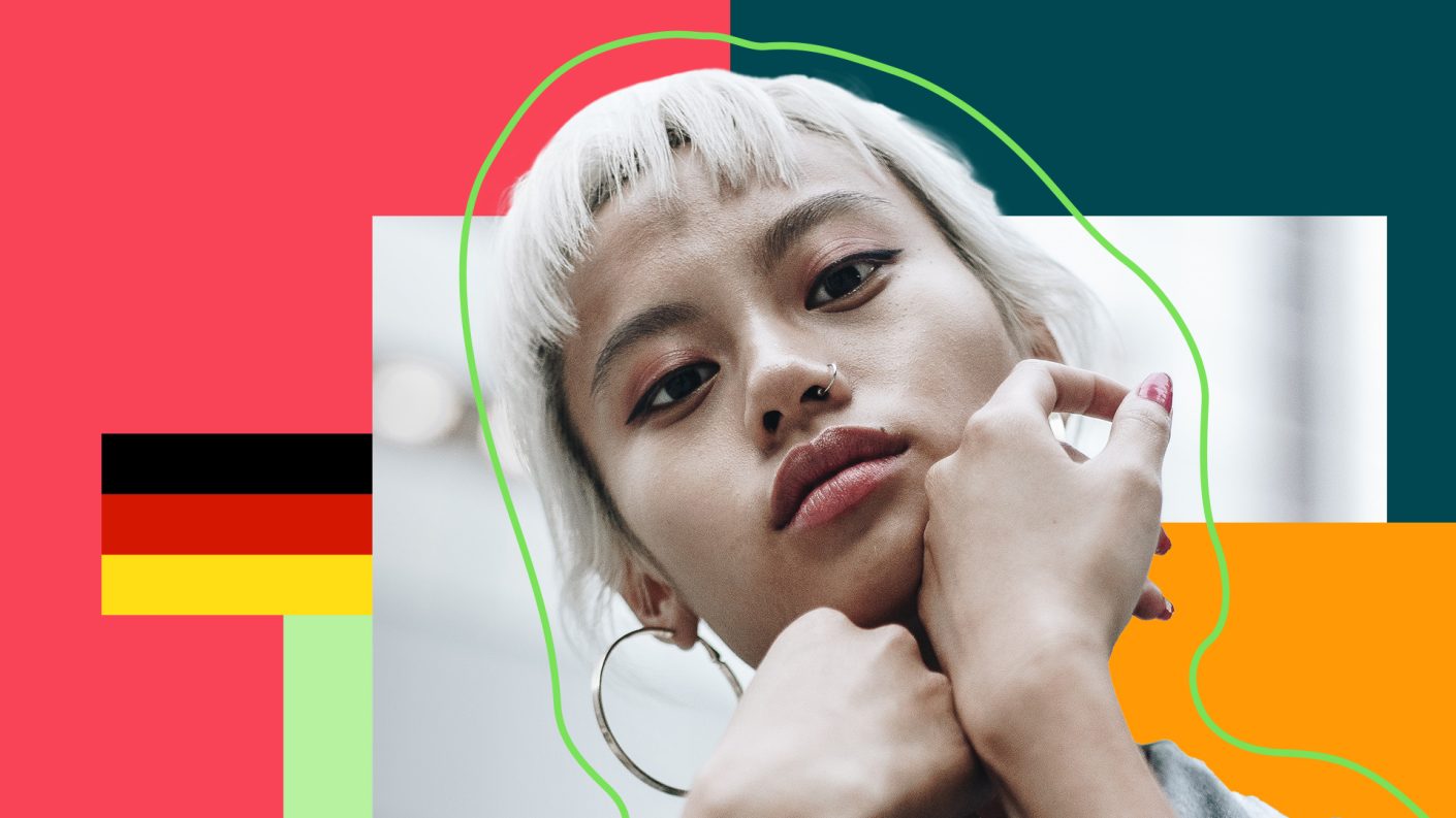 Woman looking straight at the camera with a flag of Germany behind her