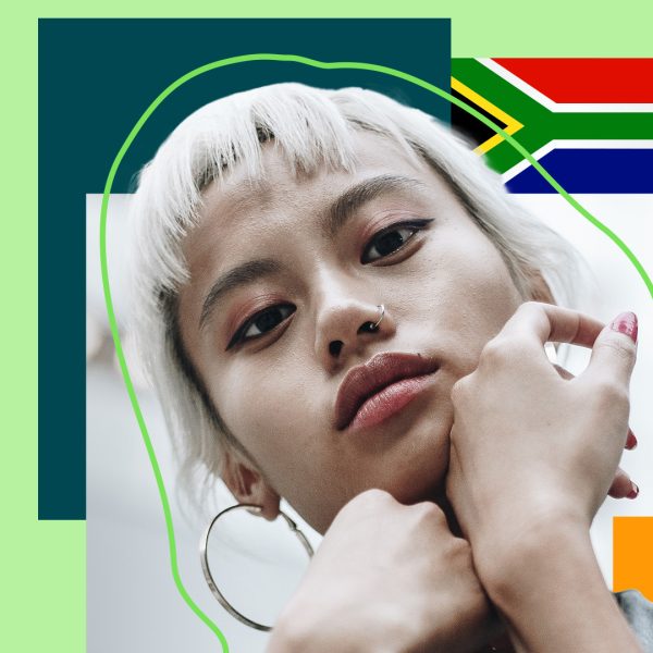 Woman looking straight at the camera with a flag of South-Africa behind her
