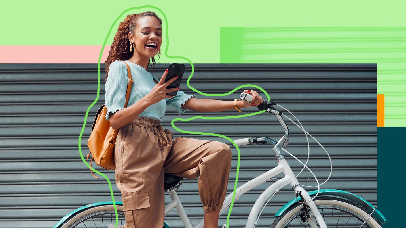 Woman on a bike, looking at her phone