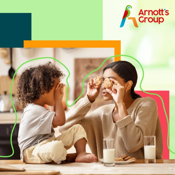 Young woman and her child holding cookies in front of their eyes