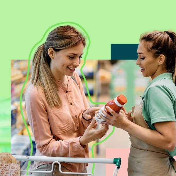 Two women in the supermarket talking over a bottle