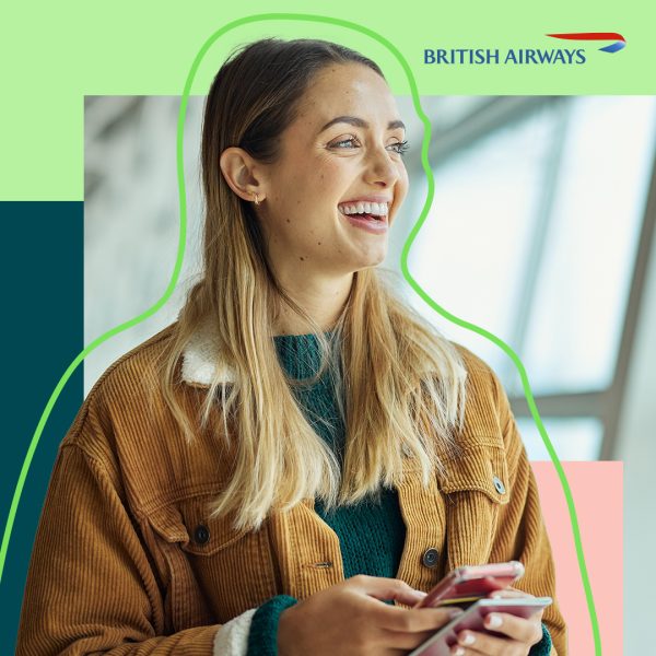 Woman smiling while looking at her phone at the airport