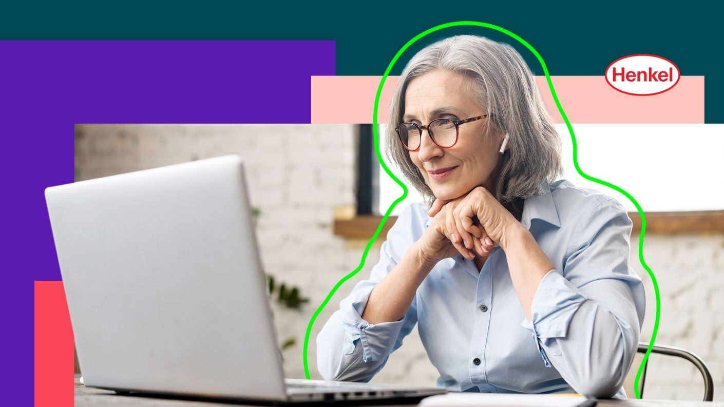 Woman with grey hair looking at her open laptop