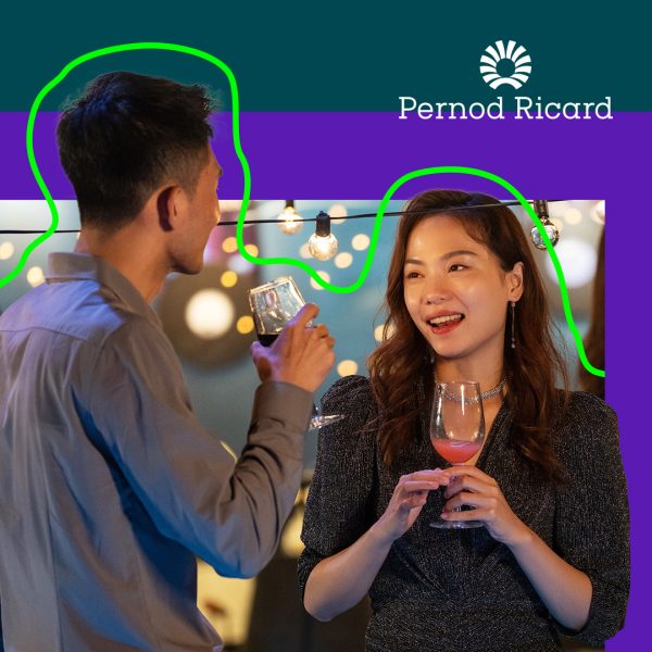 Male and female holding a drink, talking at a party