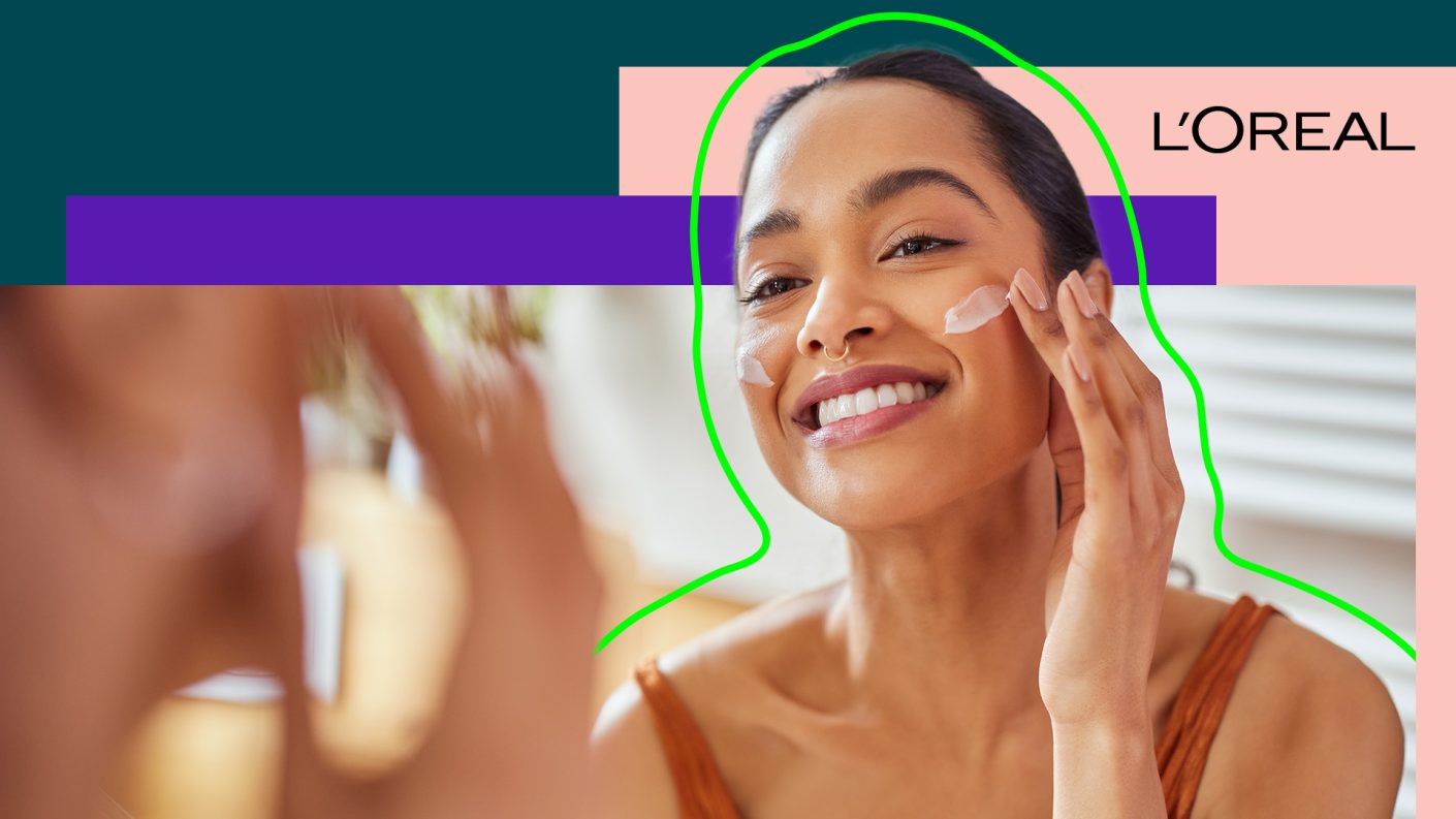 A woman is wiping cream on her face.