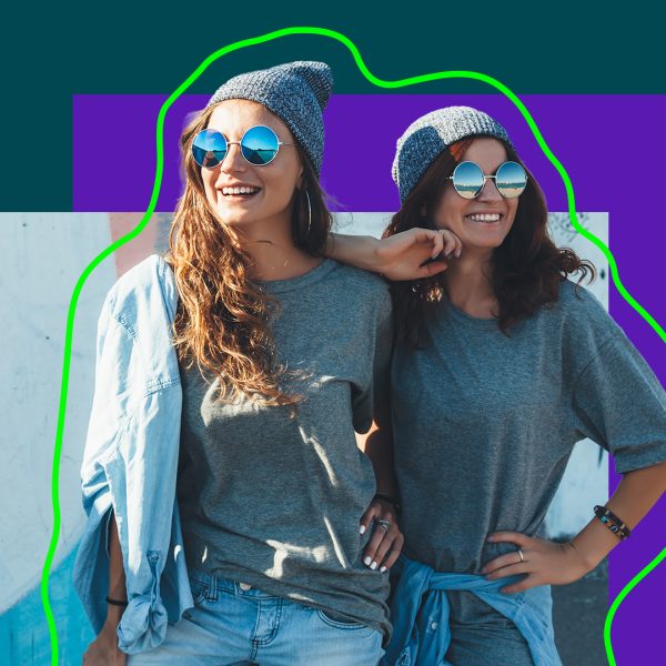 Two girls wearing beanies and sunglasses, dressed similar.