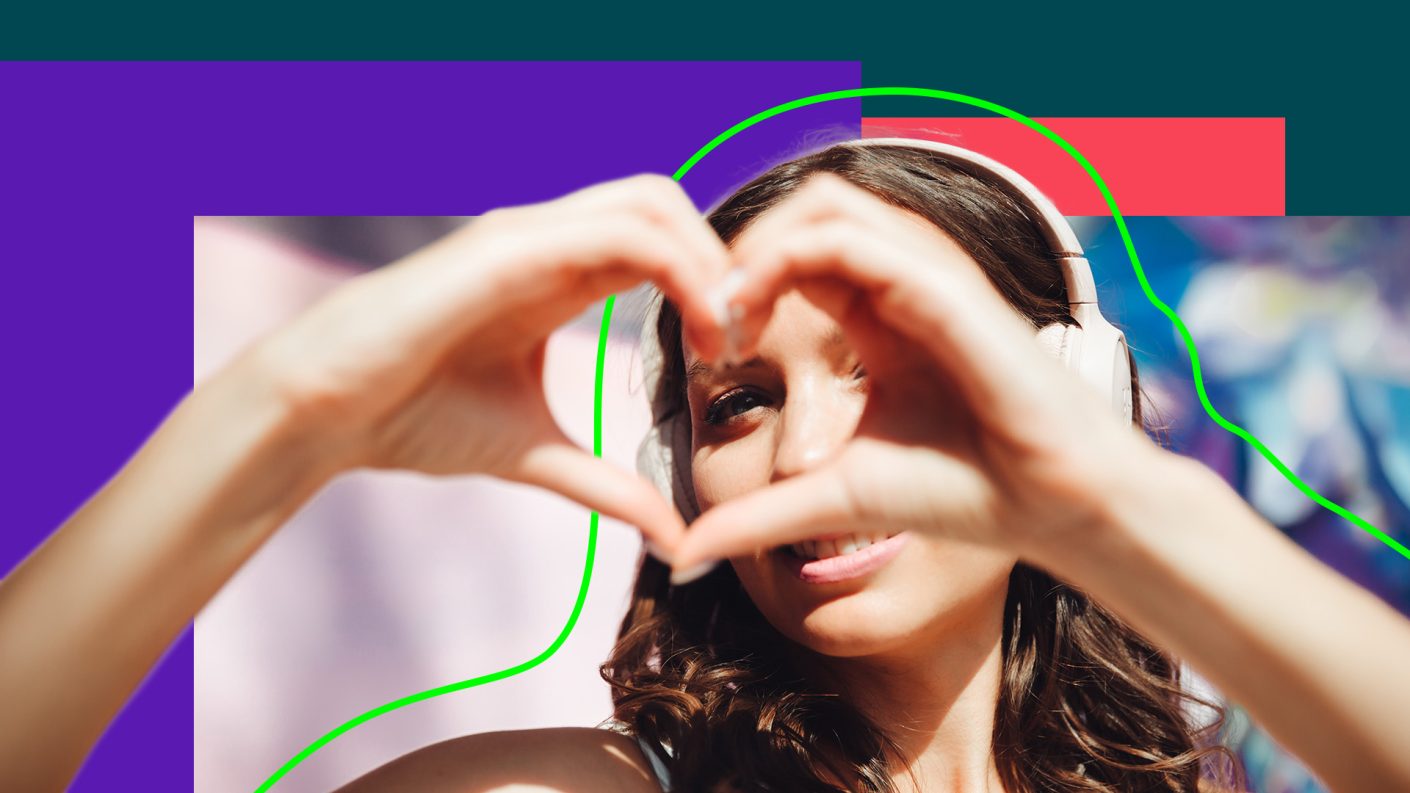 Woman wearing headphone, making heart shape with hands