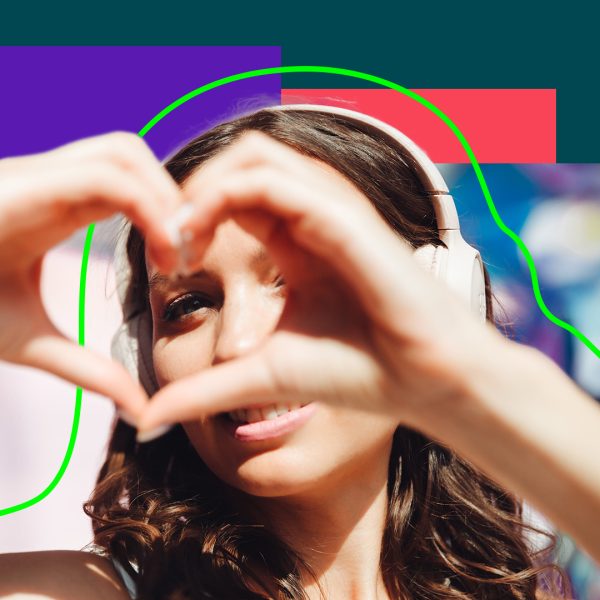 Woman wearing headphone, making heart shape with hands