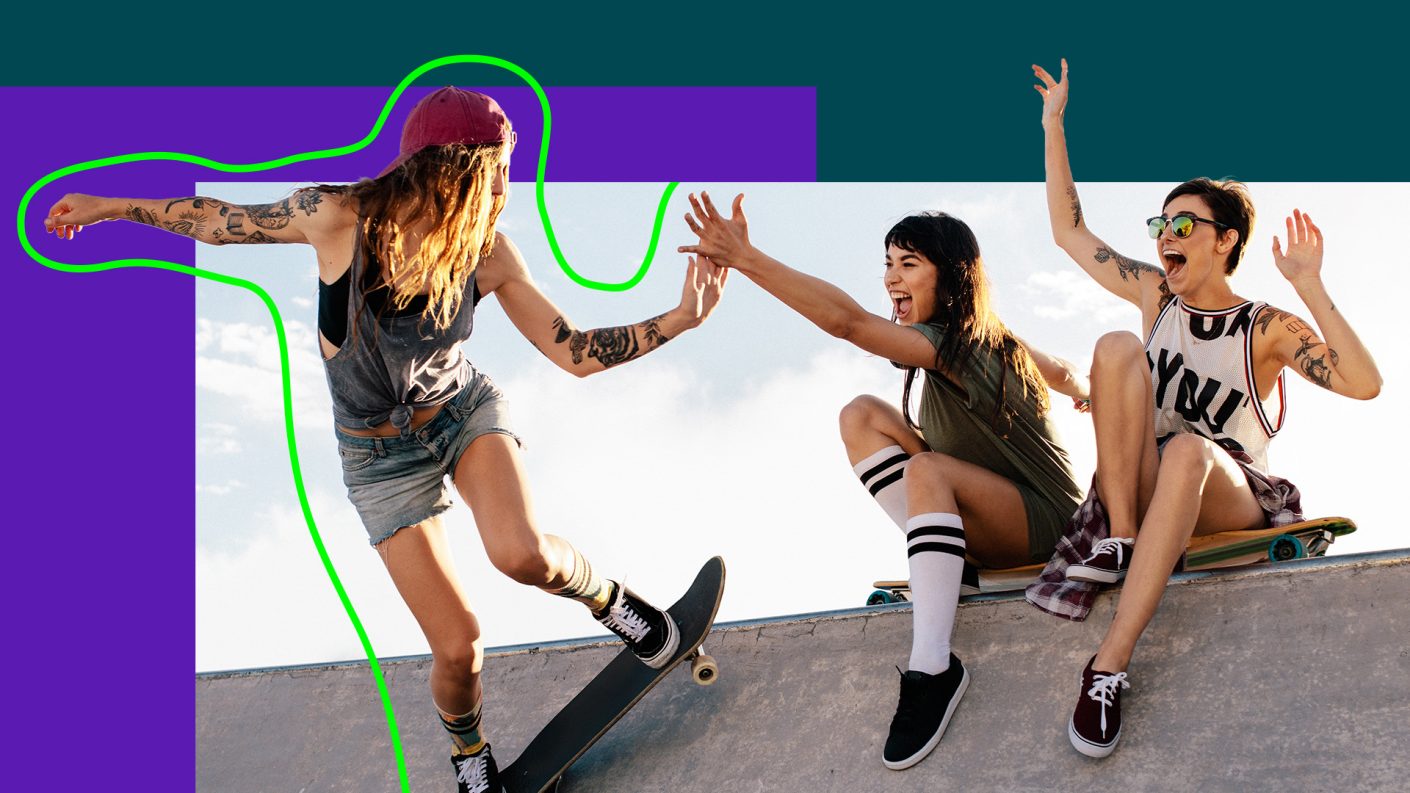 girl skateboarding on ramp while high fiving friend