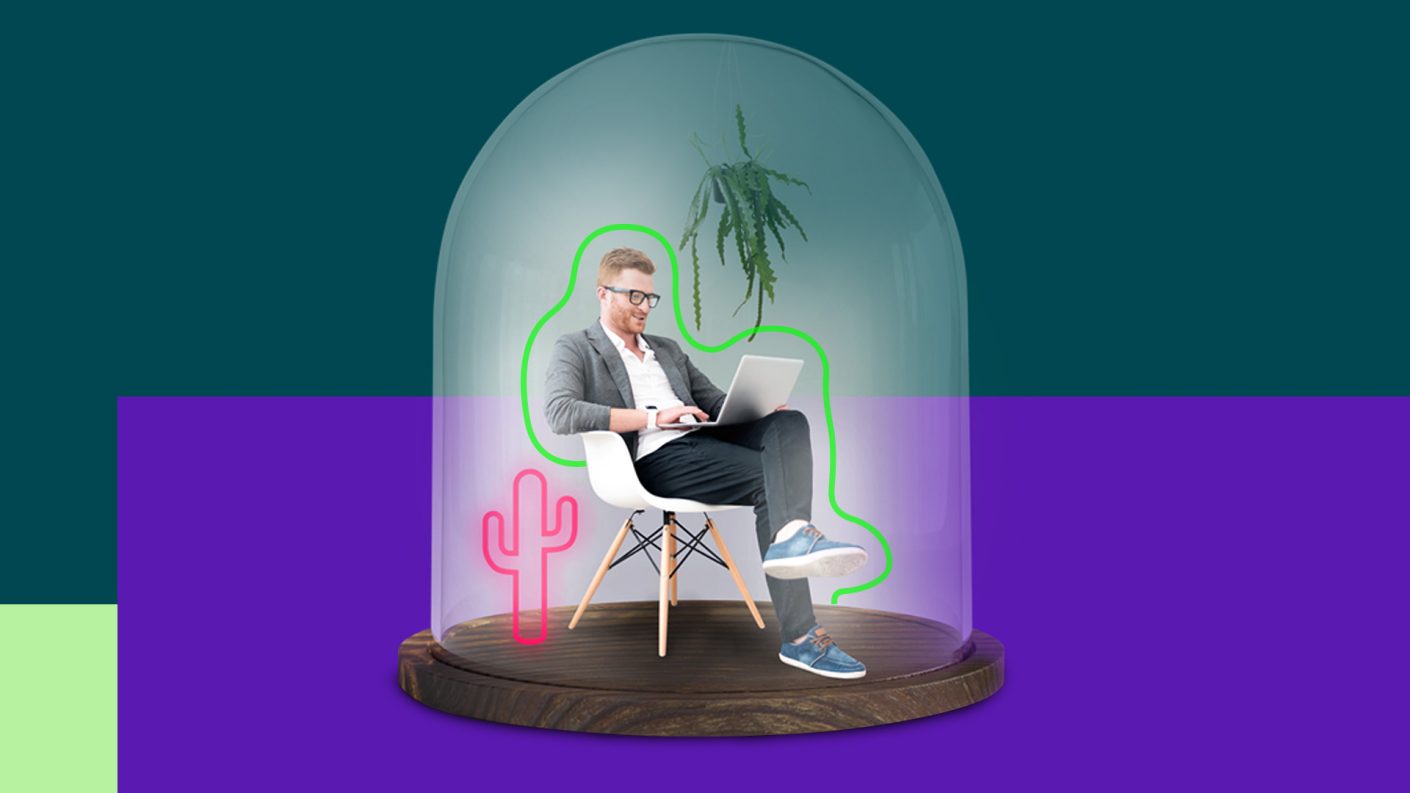 Man sitting in white chair and working on a laptop in a glass dome