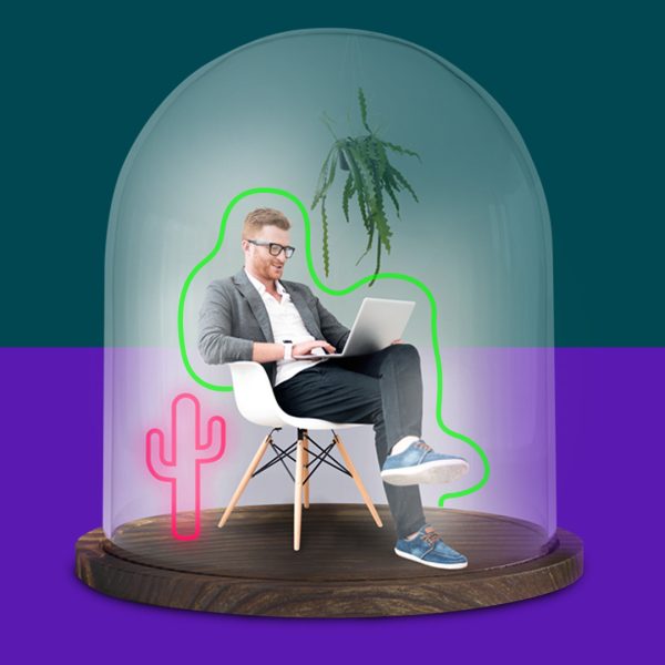 Man sitting in white chair and working on a laptop in a glass dome