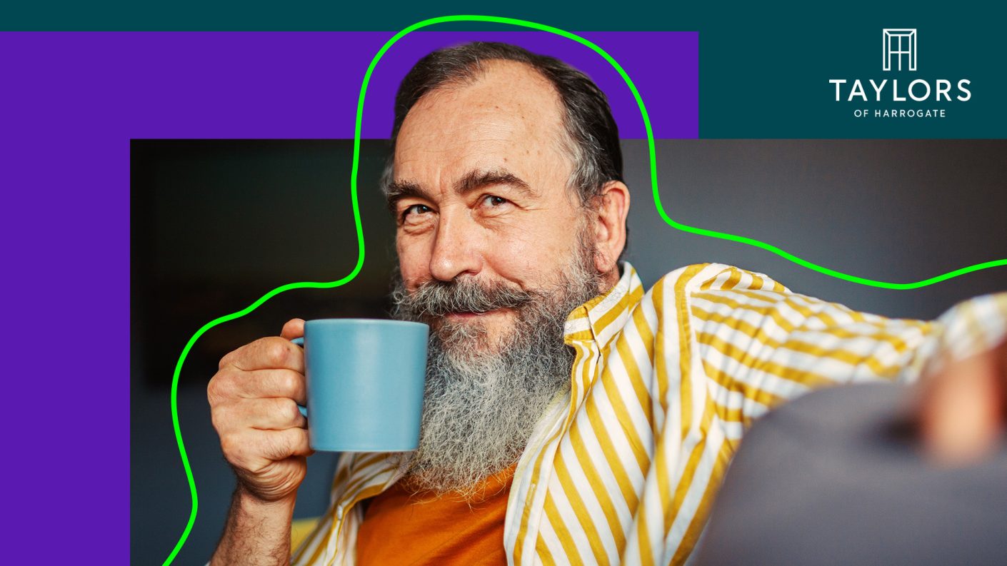 Man with beard drinking coffee from a blue cup