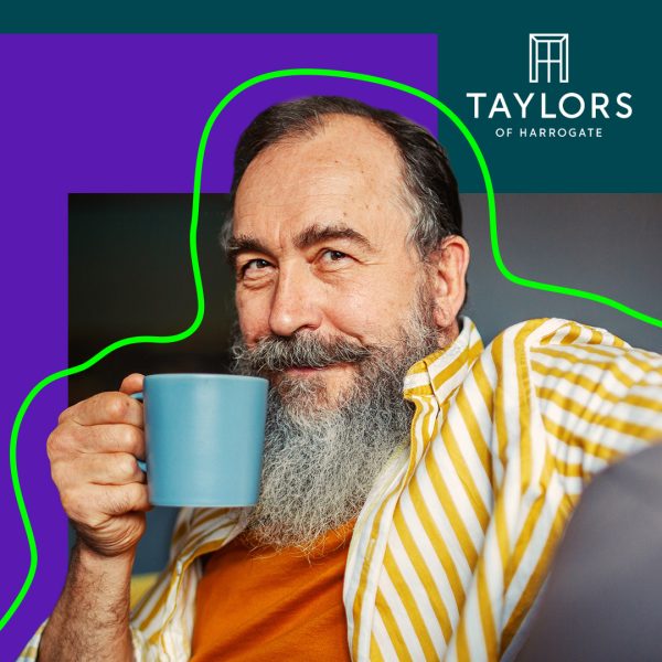 Man with beard drinking coffee from a blue cup