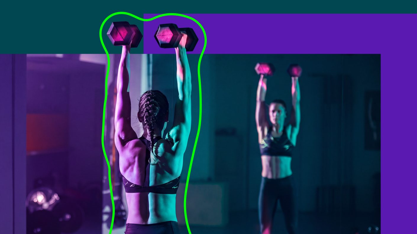 Woman weightlifting and looking in the mirror